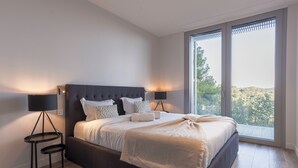 A modern bedroom with a large bed, two bedside lamps, and a view of the outdoors through a large window. - Villa Key West Mougins - Luxury & Serenity & Swimming pool (Mougins)