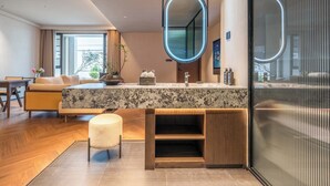 A modern bathroom with a large mirror, a marble countertop, and a wooden vanity. - Yi Nian Fangcun Hotel (Nanchang)