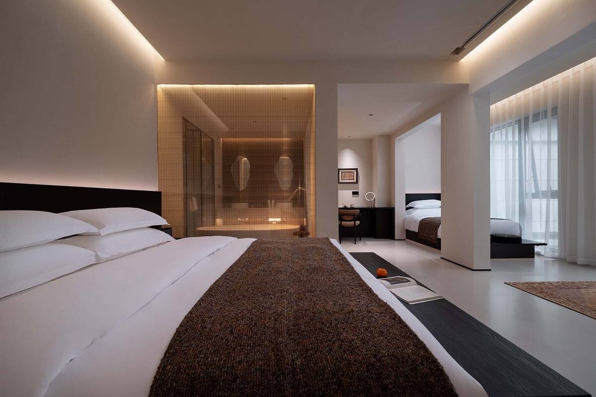 Une chambre d’hôtel moderne dotée d’un grand lit, d’un bureau et d’un coin salon.