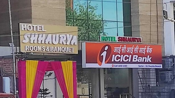 A hotel building with a modern facade, large windows, and signs for 'Hotel Shhaurya' and 'ICICI Bank'. - HOTEL SHHAURYA  (New Delhi)