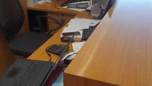 A cluttered office desk with a laptop, keyboard, calculator, and various papers. - HOTEL SHHAURYA  (New Delhi)