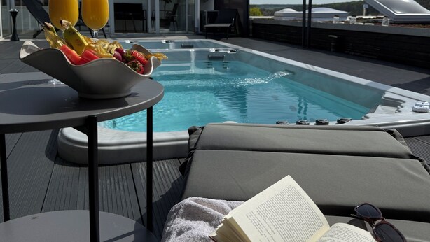 A modern outdoor pool area with a hot tub, lounge chairs, and a table with fruit and drinks. - VILLAFINE - Exclusive villa with pool & sauna in Vaihingen an der Enz (Aurich, Vaihingen an der Enz)