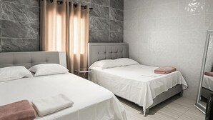 A hotel room with two beds, a mirror, and a bathroom. - Charming 3-bedroom chalet, with private pool, an with AC. (Malambo)