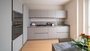 A modern kitchen with grey cabinets, a built-in oven, a gas stove, and a sink. - VILLA La No. 1 - Spacious & Modern (MONTICELLI BRUSATI)