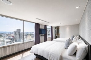 A hotel room with a large bed, a television, and a city view. - ElEnce Hotel (Taichung)