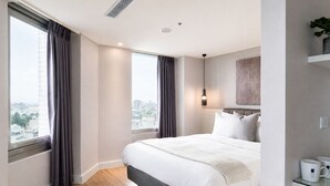 A modern hotel room with a large bed, a city view, and a minimalist design. - ElEnce Hotel (Taichung)