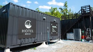 A black container with "HOTEL" and "WELCOME" signage, a staircase, and a small building. - C HOTEL -Biei Shirogane Pet Allowed (Biei)