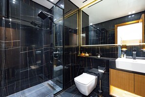 Une salle de bain moderne avec une douche à parois de verre, des toilettes blanches et un meuble-lavabo avec un miroir.