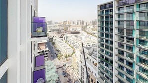 A high-rise building with multiple balconies and a view of a cityscape. - Bloomfields Cozy 1Br Binghatti House  (Dubai)