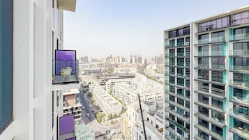 A high-rise building with multiple balconies and a view of a cityscape.