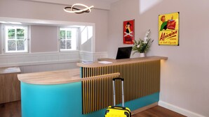 A reception area with a wooden counter, a teal accent wall, and a yellow suitcase. - Wohnpark Hotel (Heppenheim)