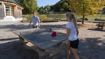 A ping pong table in an outdoor area with a building in the background.