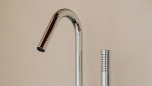 A chrome bathroom faucet with a shower head and hose. - Vitalenta Agriboutique (Pienza)