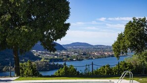 A swimming pool with a view of a lake and mountains in the background. - Villa Anna Lake View (Pilzone)