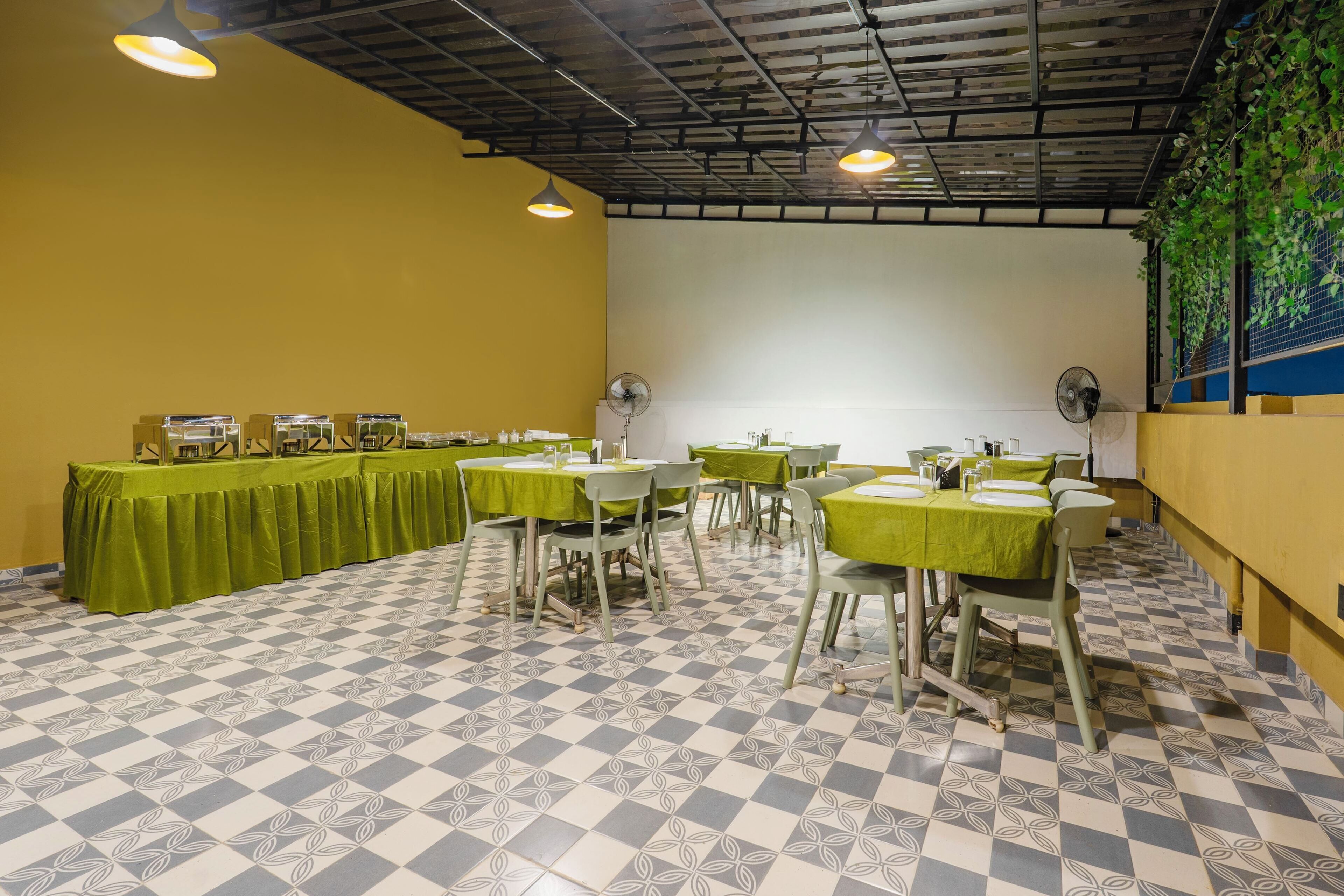 A dining area with tables set for service, a checkered floor, and a ceiling with exposed beams.