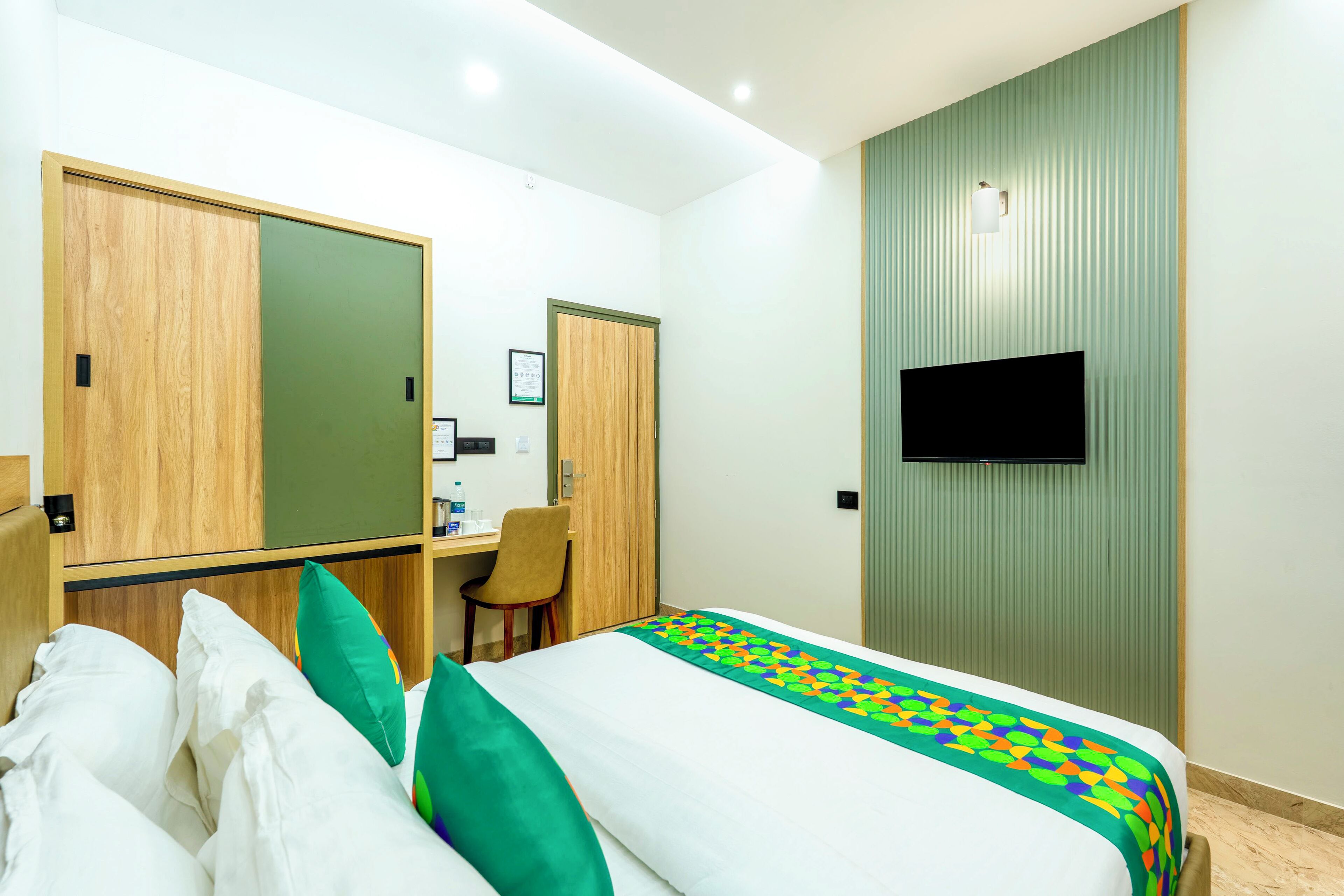 Une chambre d’hôtel comprenant un lit, un bureau, une chaise, une armoire et un téléviseur.