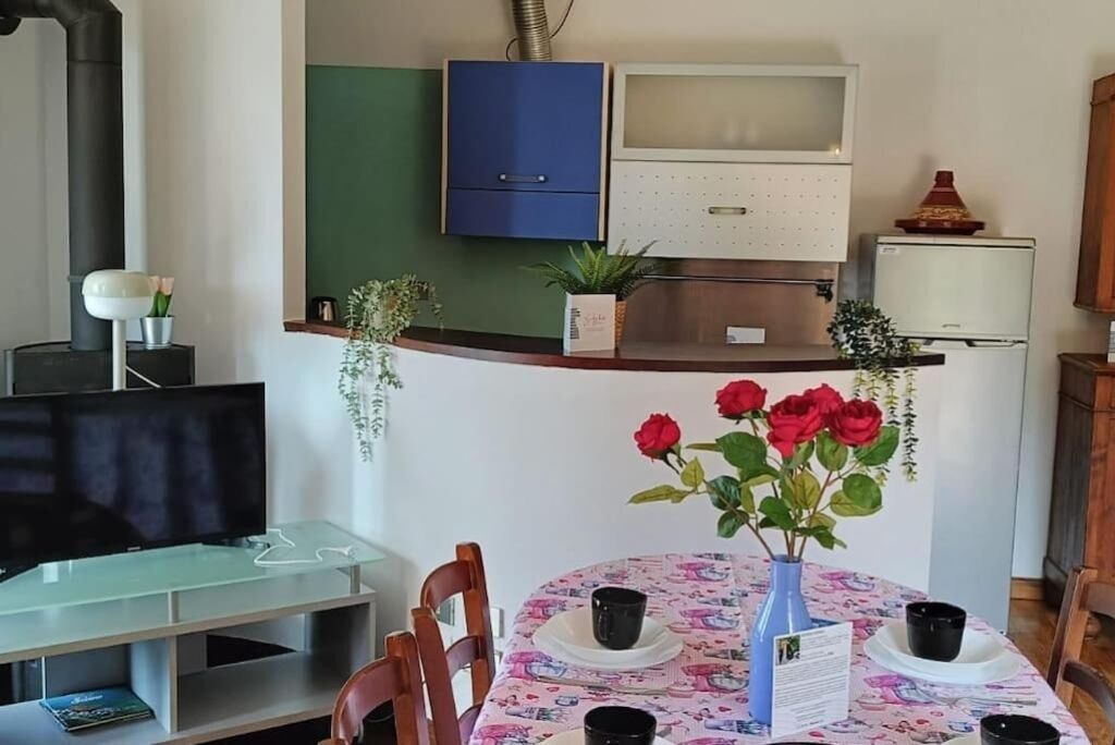 Un espacio habitable compacto con comedor, kitchenette y televisor.