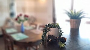 Uma mesa de jantar com uma planta em vaso e óculos de sol.