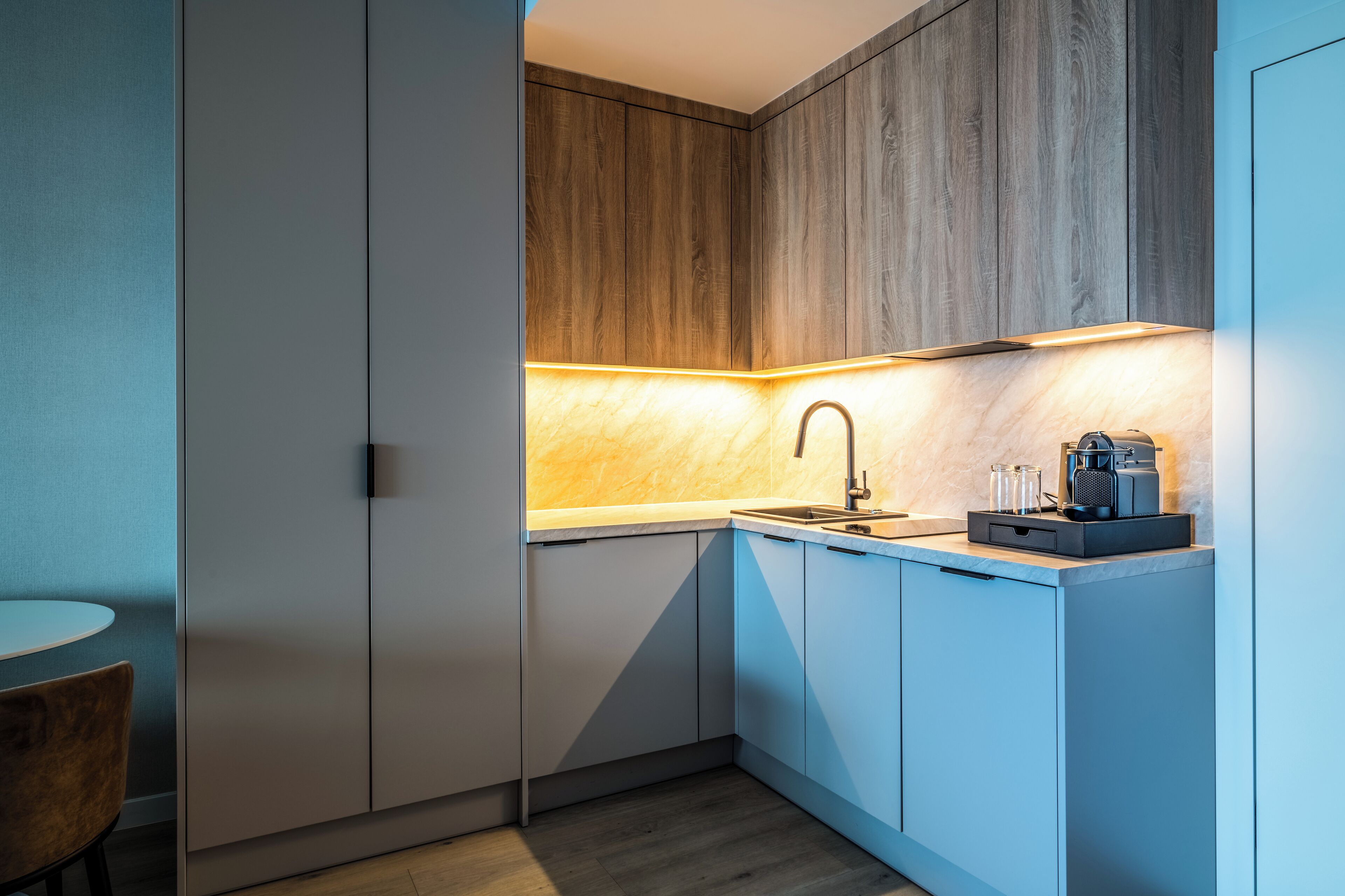 Una cocina compacta con muebles de madera, un lavamanos y una cafetera.