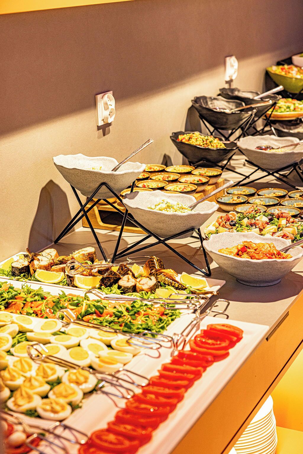 A buffet with various dishes, including salads, seafood, and pasta.