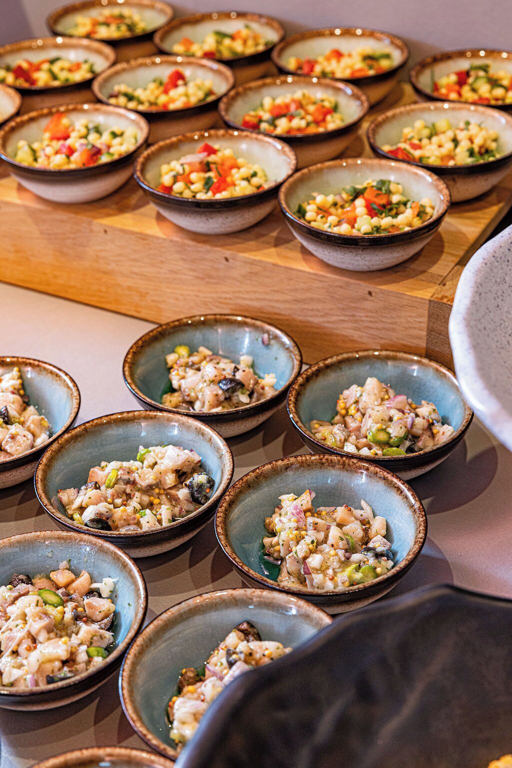 A table with multiple bowls of food, likely a buffet or tasting event.