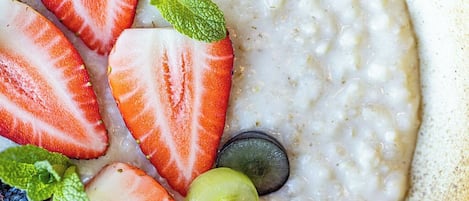 Uma tigela de aveia com morangos, mirtilos, uvas e framboesas.