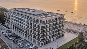 A multi-story building with a rooftop terrace, adjacent to a waterfront promenade. - Baltic View Resort & Spa, A Member Of Radisson Individuals (Miedzyzdroje)