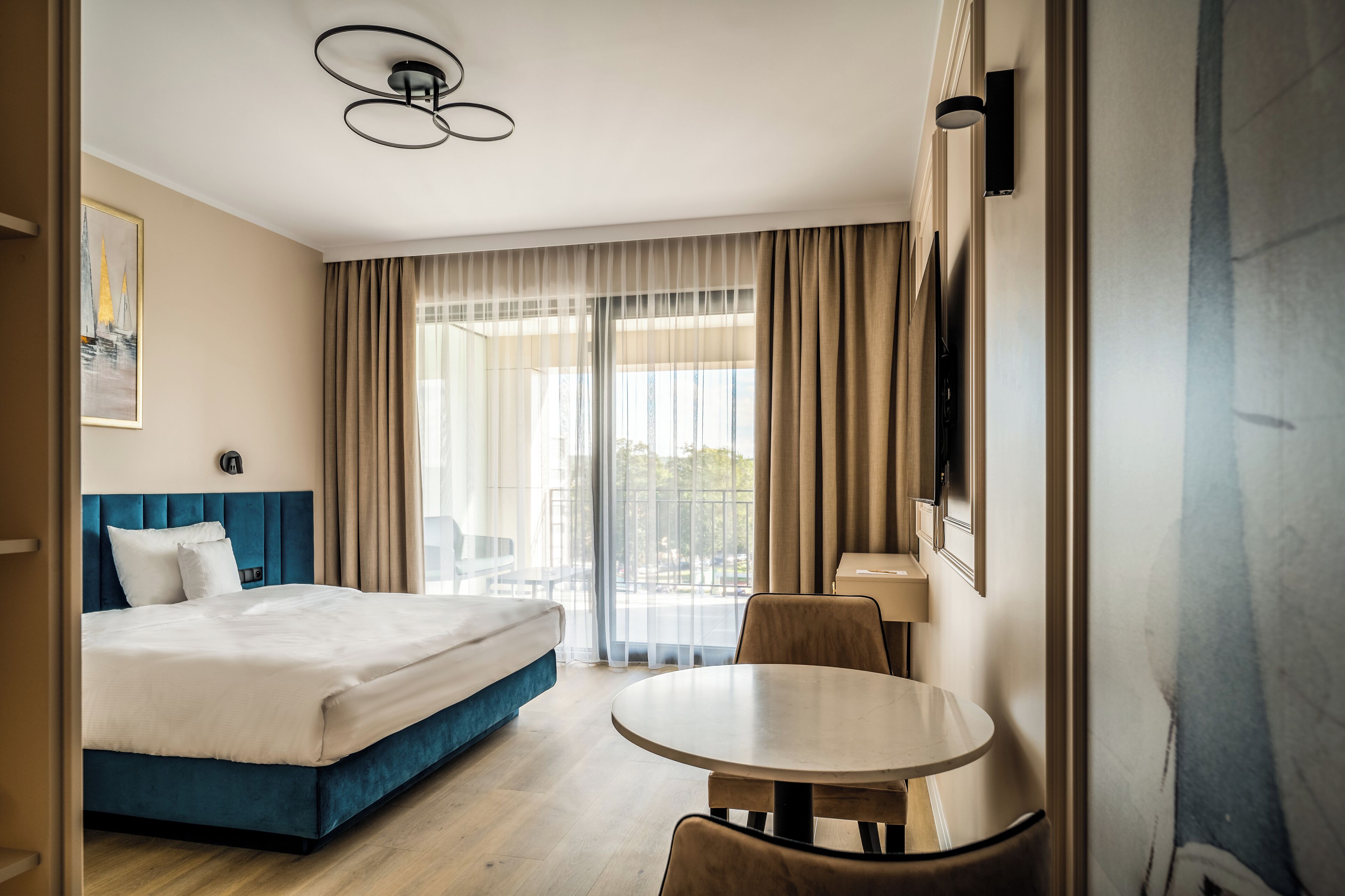 Une chambre d’hôtel avec un lit, une table ronde, une chaise et un téléviseur.