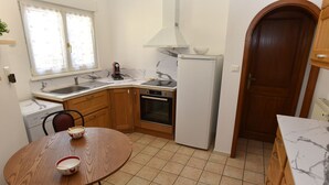A compact kitchen with a sink, stove, oven, and a dining table with chairs. - Pavilion well located for visiting the region (Ruelisheim)