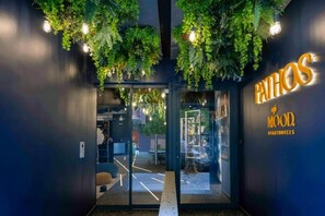 Rakennuksen sisäänkäynti, jonka yläpuolella on kyltti, jossa lukee: ”PATHOS MOOD APARTMENTS”.