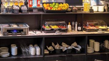 A buffet area with various food items, condiments, and beverages.