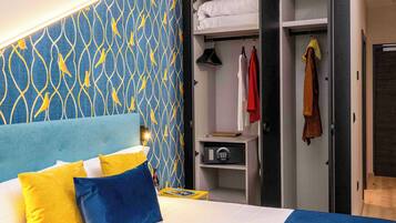 A hotel room with a bed, a wardrobe, and a nightstand.
