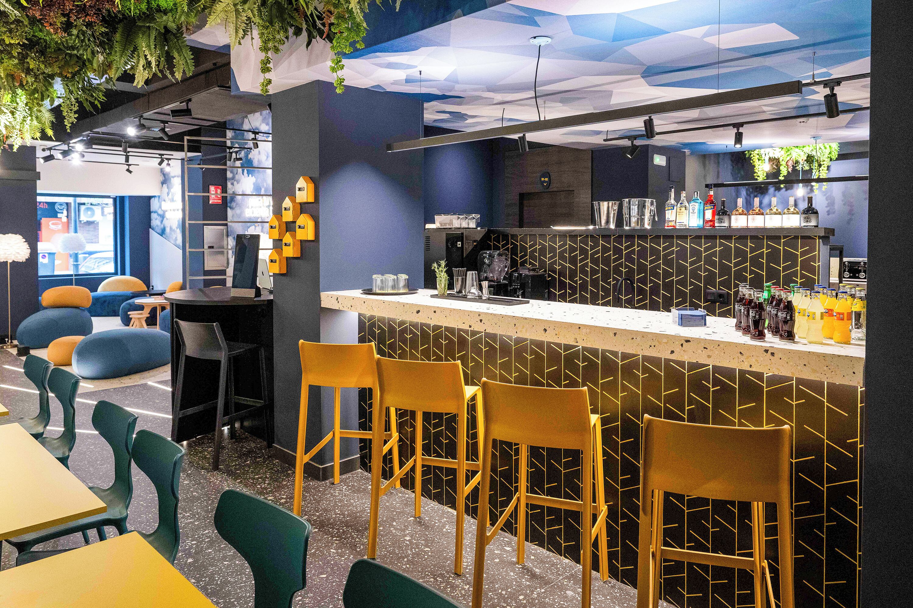 Un espace bar moderne avec un comptoir, des tabourets de bar et des sièges.
