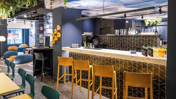 Un espace bar moderne avec un comptoir, des tabourets de bar et des sièges.