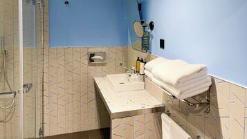 Ein Badezimmer mit Dusche, Waschbecken und Handtuchhalter.