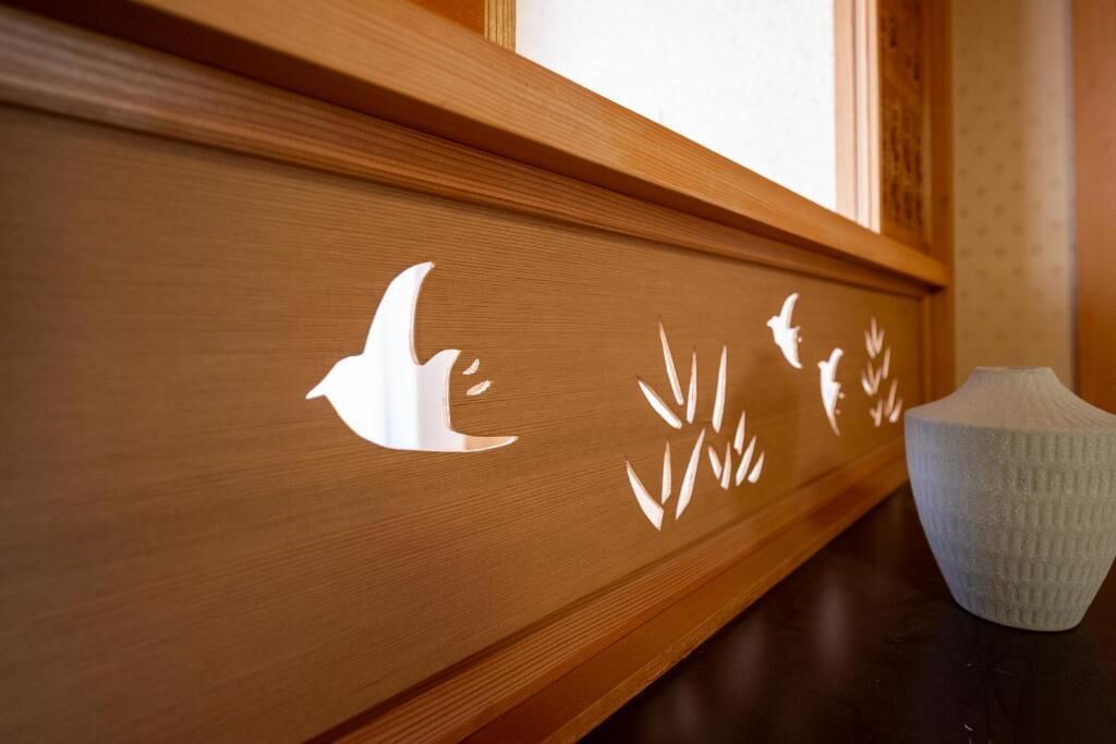 Un panneau en bois orné de motifs sculptés représentant des oiseaux et des plantes.