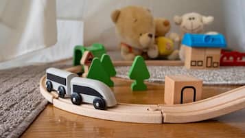 A wooden toy train set with a track, a bear, and a house.
