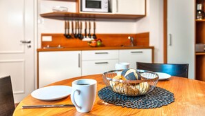 Ein Esstisch mit einer Schüssel Brot, einer Kaffeetasse und einem Teller.
