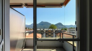 A balcony with a view of mountains and buildings.