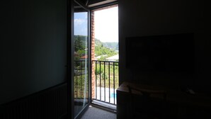 Une pièce dotée d’une grande fenêtre, offrant une vue sur le paysage urbain, et comprenant un bureau en bois.