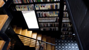 Un escalier donnant sur une bibliothèque remplie de livres.