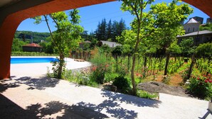 Une vue à travers une arche donnant sur une piscine, un jardin et des immeubles résidentiels.