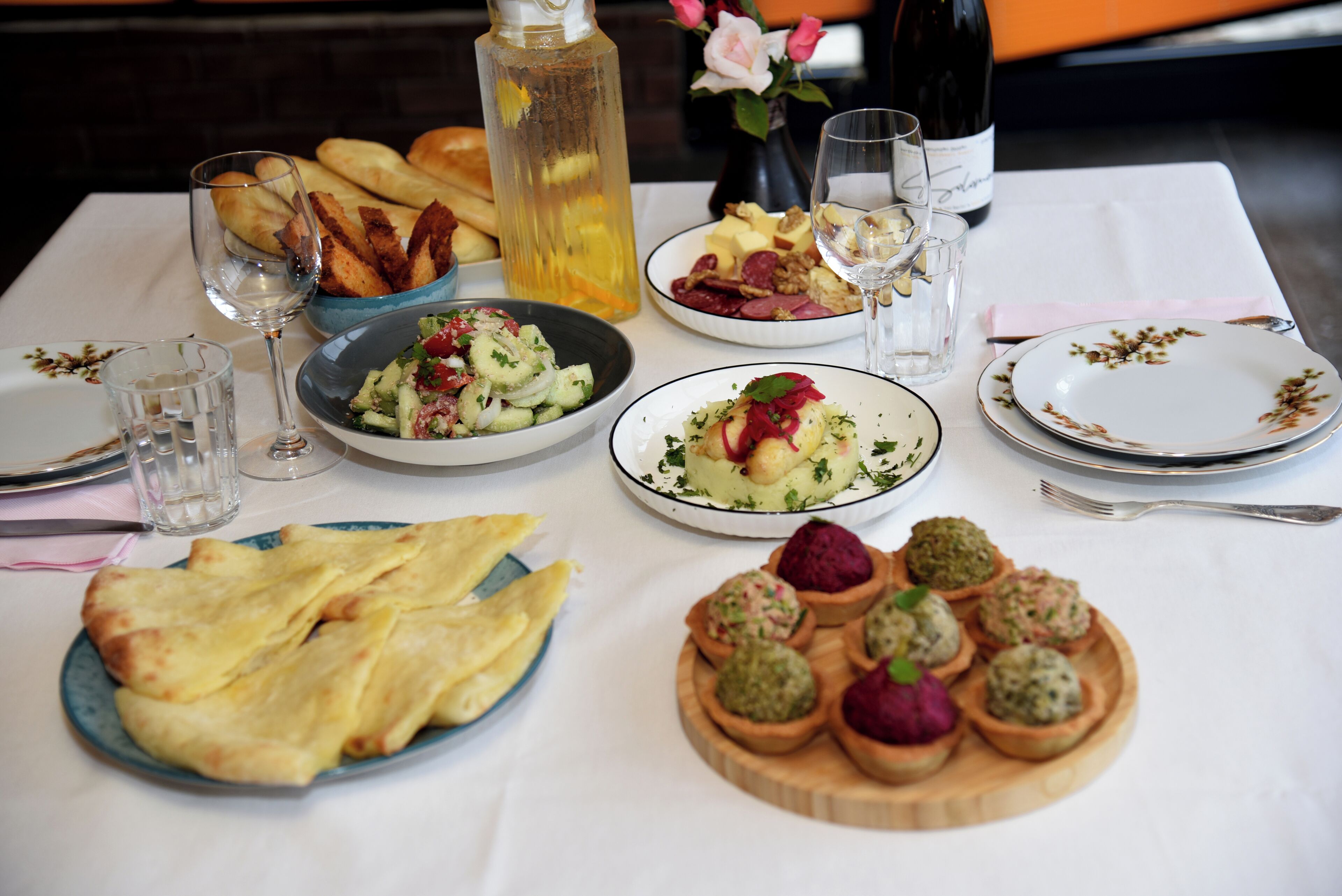 Un tavolo da pranzo imbandito con piatti, bicchieri e una bottiglia di vino.