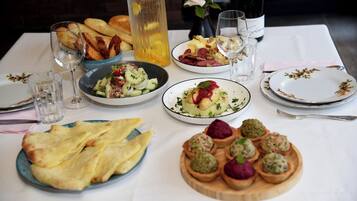 Un tavolo da pranzo imbandito con piatti, bicchieri e una bottiglia di vino.