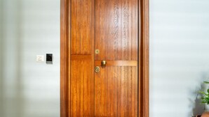 A wooden door with a brass handle and a lock.
