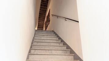 Eine Treppe mit Metallgeländer und einem an der Wand befestigten Ablagefach.