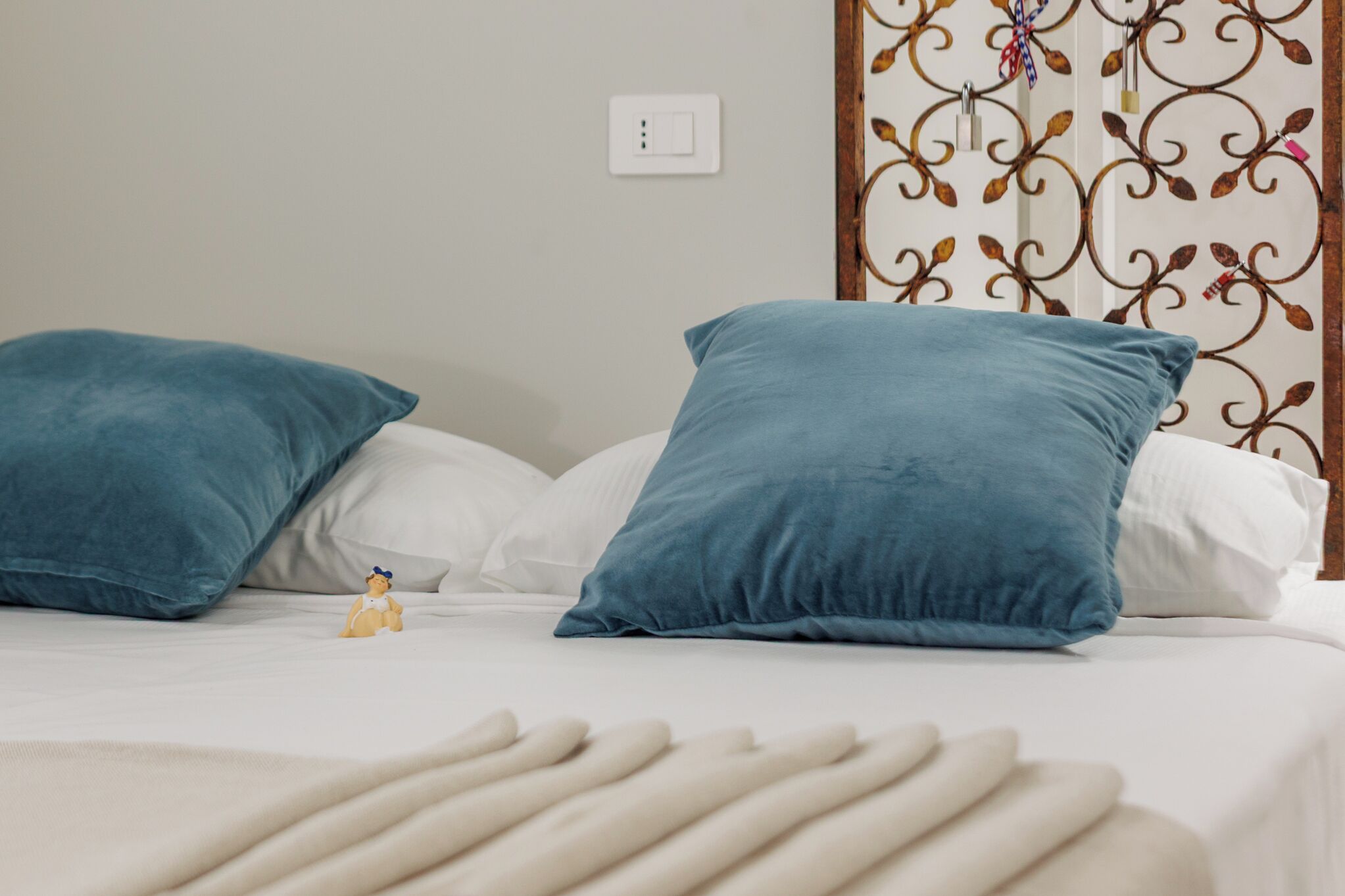 A bed with two blue pillows and a small figurine.