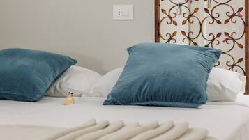 A bed with two blue pillows and a small figurine.