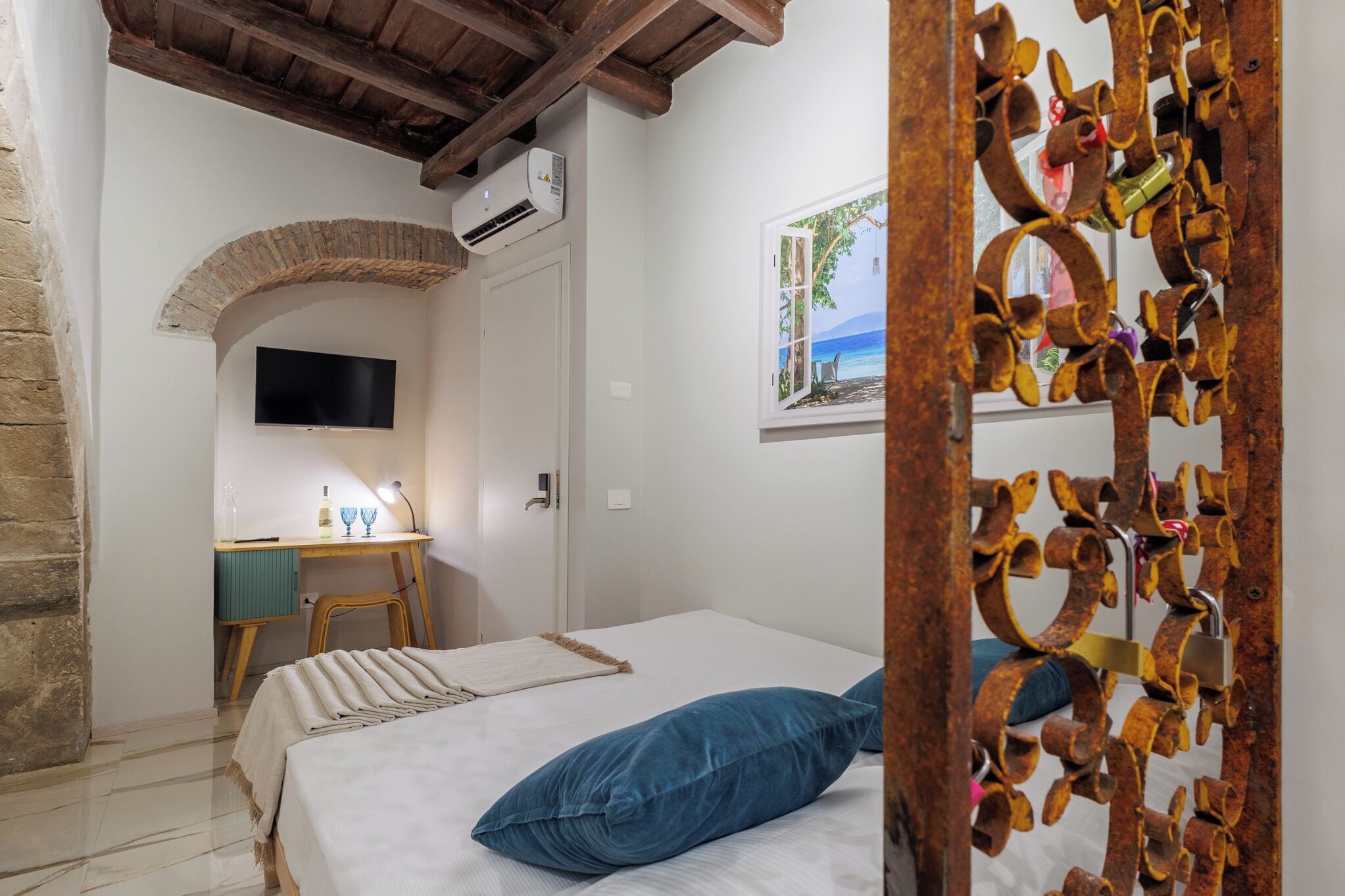 Une chambre à coucher avec un lit, un bureau et une chaise, une télévision et une fenêtre donnant sur un beau paysage.