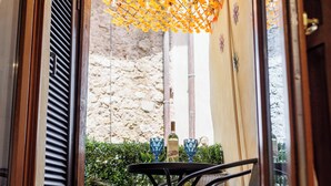 A view from a window with a stone wall and a table with two glasses and a bottle. - SOHO Fontana Grande By Dasso (Viterbo)